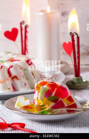 A cream cake with jelly pieces of different colors on a light background. Valentine's Day dessert. Stock Photo