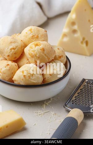 Food, Brazilian cheese bread. Freshly baked homemade cheese buns in a white plate on a light background. A gourmet snack. Delicious pastries. Selectiv Stock Photo