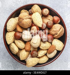 Food, Tasty and healthy assorted nuts in the peel-almonds, hazelnuts, pecans, walnuts. Gourmet snack. Proper food. Selective focus. Square picture Stock Photo