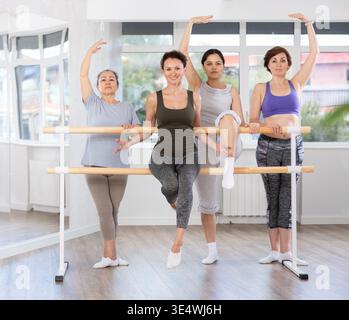 Female instructor of ballet class for adult amateurs posing with group Stock Photo