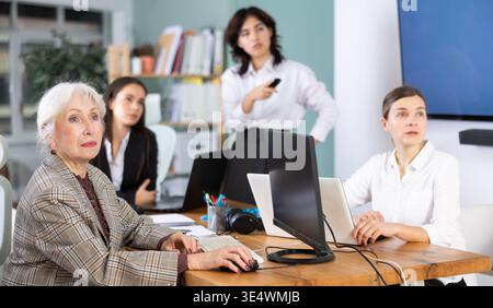 Female colleagues watching a project presentation in modern office Stock Photo