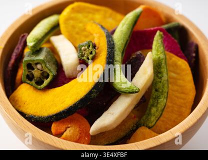 Close-up of assorted colorful vegetable chips in a wooden bowl, focus on texture Stock Photo