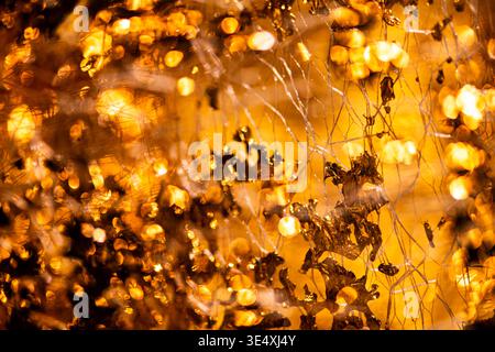 Golden luxury backdrop in glossy shimmer. Golden reflective gold foil on wallpaper. Golden abstract pattern for jewelry. Golden glowing surface. Stock Photo