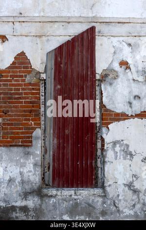 Window in old building covered with rusty corrugated iron for use as a background Stock Photo