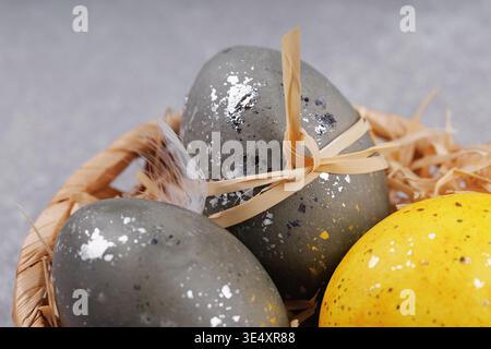 Close up Easter eggs with feathers in wicker basket Stock Photo