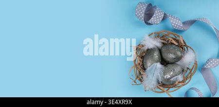 Flat lay Easter eggs nest with ribbon and feathers Stock Photo