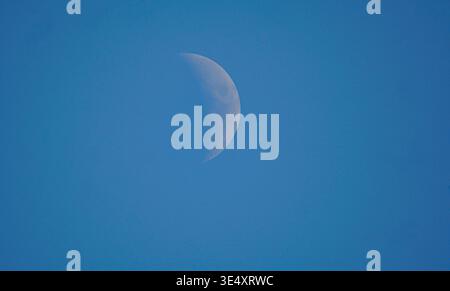 Half full moon and blue sky, moon during the day Stock Photo