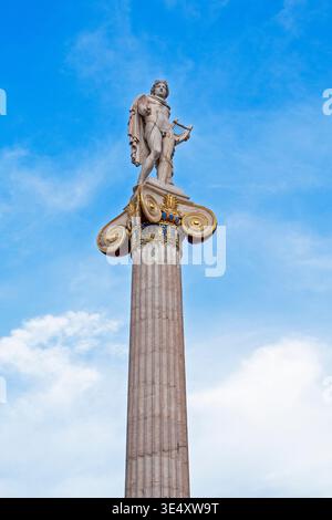 marble statue of Apollo on an Ionic column against a blue sky Stock Photo