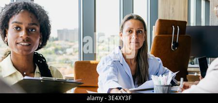 Experts engaged in lively debate amid urban workspace setting Stock Photo