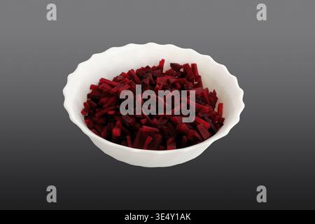 Beetroot sliced into strips. In a white plate. Close-up. Isolated on grey background. Stock Photo