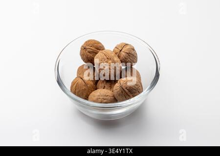 Whole shelled walnuts kept in a glass bowl Stock Photo