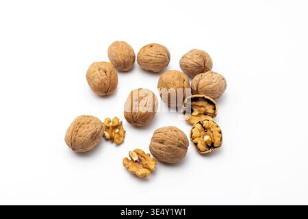 Close up of whole shelled walnuts and walnut kernels against a white background Stock Photo