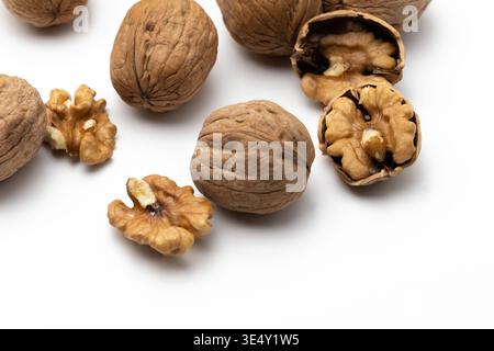 Close up of whole shelled walnuts and walnut kernels against a white background Stock Photo