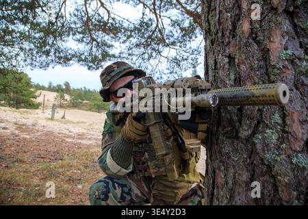 Armed Soldier in Camouflage in the Forest Stock Photo