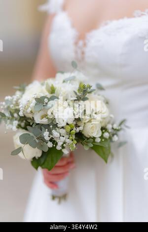 Close-up of bridal bouquet with white flowers and greenery. Elegant wedding detail with soft focus and romantic atmosphere. Perfect for wedding and Stock Photo
