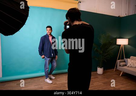 Photographer shooting male model in a professional studio Stock Photo