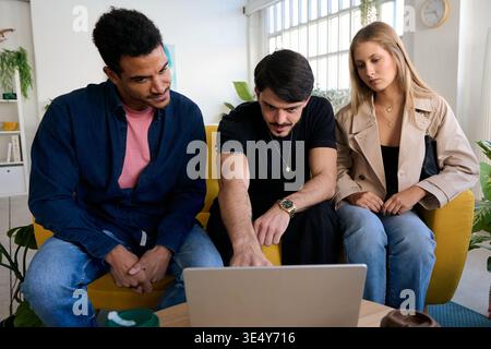 Diverse friends collaborating discussing information on laptop Stock Photo