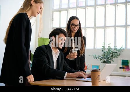 Business people collaborating on laptop in modern office Stock Photo