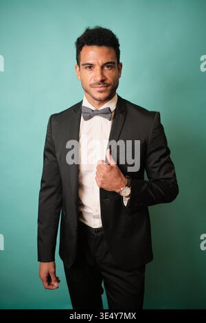 Confident man wearing black suit and gray bow tie Stock Photo