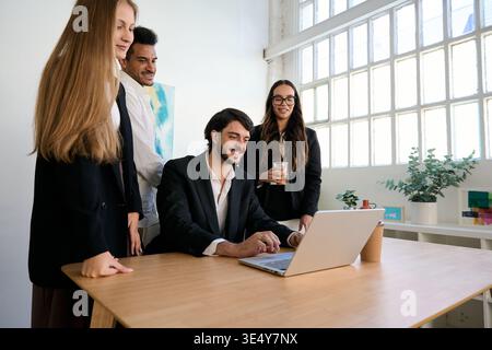 Diverse business team collaborating using laptop in office Stock Photo