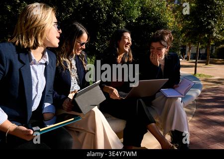 Businesswomen collaborating outdoors laughing during a meeting Stock Photo