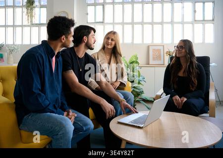 Diverse startup team collaborating on a project in a modern office Stock Photo