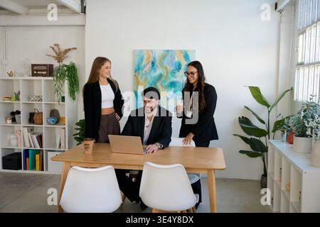 Business team collaborating on laptop in modern office Stock Photo