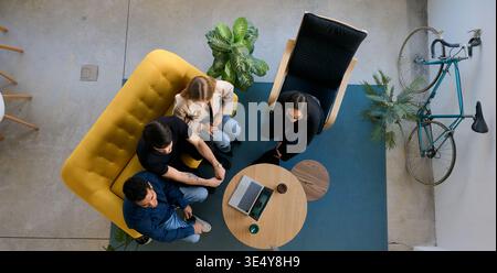Diverse startup team collaborating in modern coworking office Stock Photo