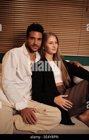 Loving multicultural couple relaxing together on a couch Stock Photo