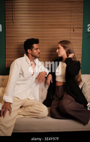 Interracial couple having serious conversation on couch Stock Photo