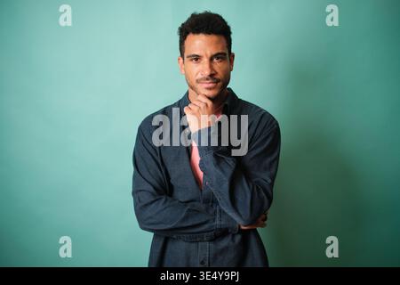 Confident man with thoughtful expression looking at camera Stock Photo