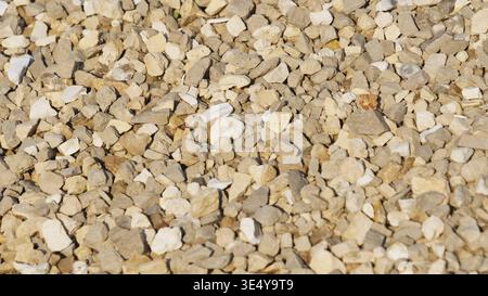 Crushed grey and beige stone creating a uniform rough background texture Stock Photo