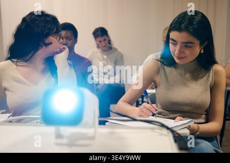 Students learning in classroom with projector for education Stock Photo
