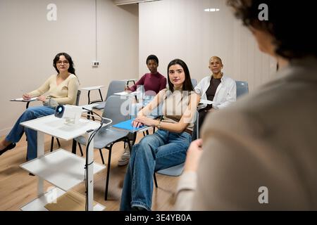 Diverse women students attending university lecture in classroom Stock Photo