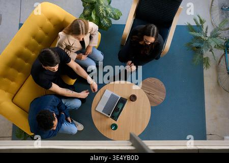 Diverse team meeting collaborating in modern office lounge Stock Photo