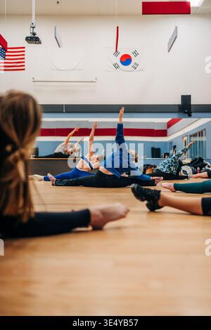 Group of women stretching in a split during fitness class Stock Photo