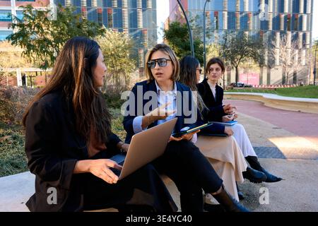 Business women having outdoor meeting collaborating on laptop Stock Photo