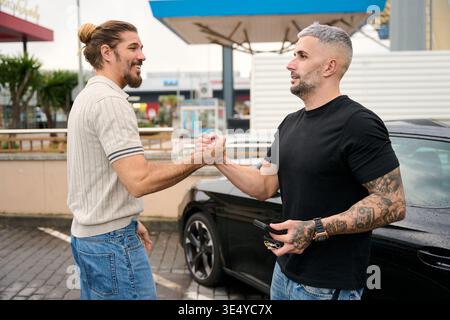Two young men greeting each other outdoors Stock Photo