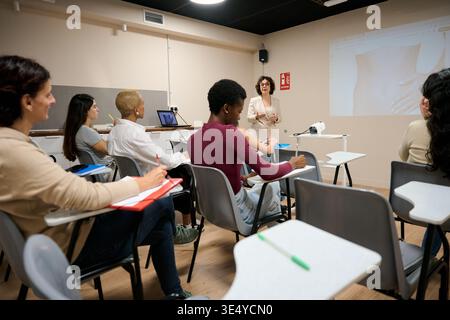 Diverse students learning during presentation in classroom Stock Photo