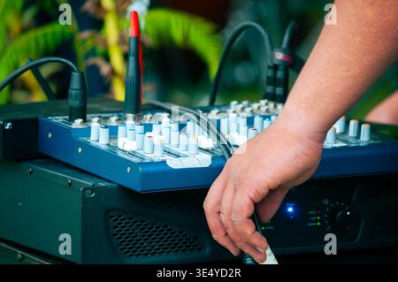 Professional audio engineer adjusting analog mixing console Stock Photo