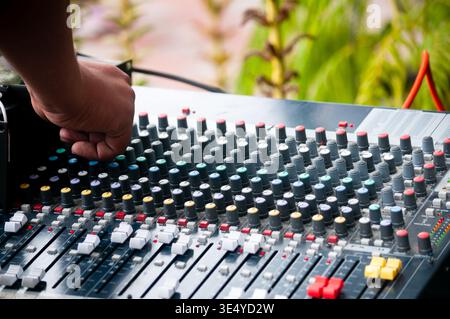 Professional audio engineer adjusting analog mixing console Stock Photo