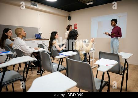 Diverse students attending a lecture in modern classroom Stock Photo