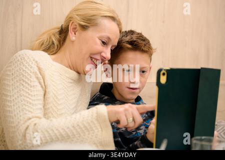 Mother and son learning together using tablet technology Stock Photo