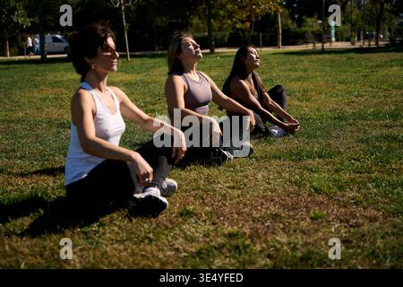 Women meditating outdoors practicing mindfulness in park Stock Photo