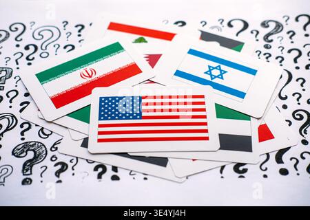 Cards showing United States, Israel, Iran, and Lebanon flags lie on paper covered in question marks. Middle East geopolitical tensions, regional Stock Photo