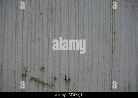Close up of an aged concrete wall with vertical striped pattern and visible stains. Stock Photo