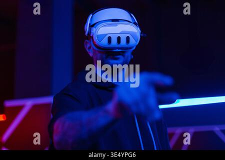 young man with beard in glasses of virtual reality on dark background.. Augmented reality, science, future technology concept. VR. Futuristic 3d glass Stock Photo