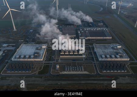 Aerial view of large data center processing vast amounts of data for cloud computing and artificial intelligence, powered by surrounding wind turbines Stock Photo