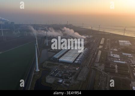Aerial view of hyperscale data center operating with steam cooling, generating artificial intelligence and large data, powered by many wind turbines Stock Photo
