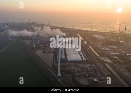 Aerial view of aerial view of a large hyperscale data center operating with surrounding wind turbines, showing cloud computing and ai infrastructure Stock Photo